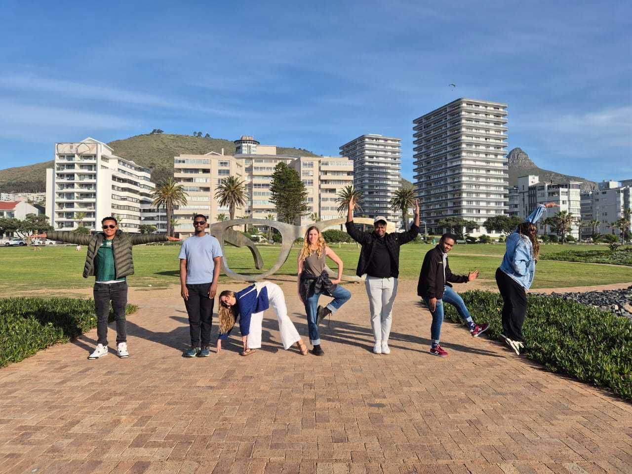 The timbuk2 team striking poses around the giant spectacles sculpture on the Sea Point promenade, Cape Town
